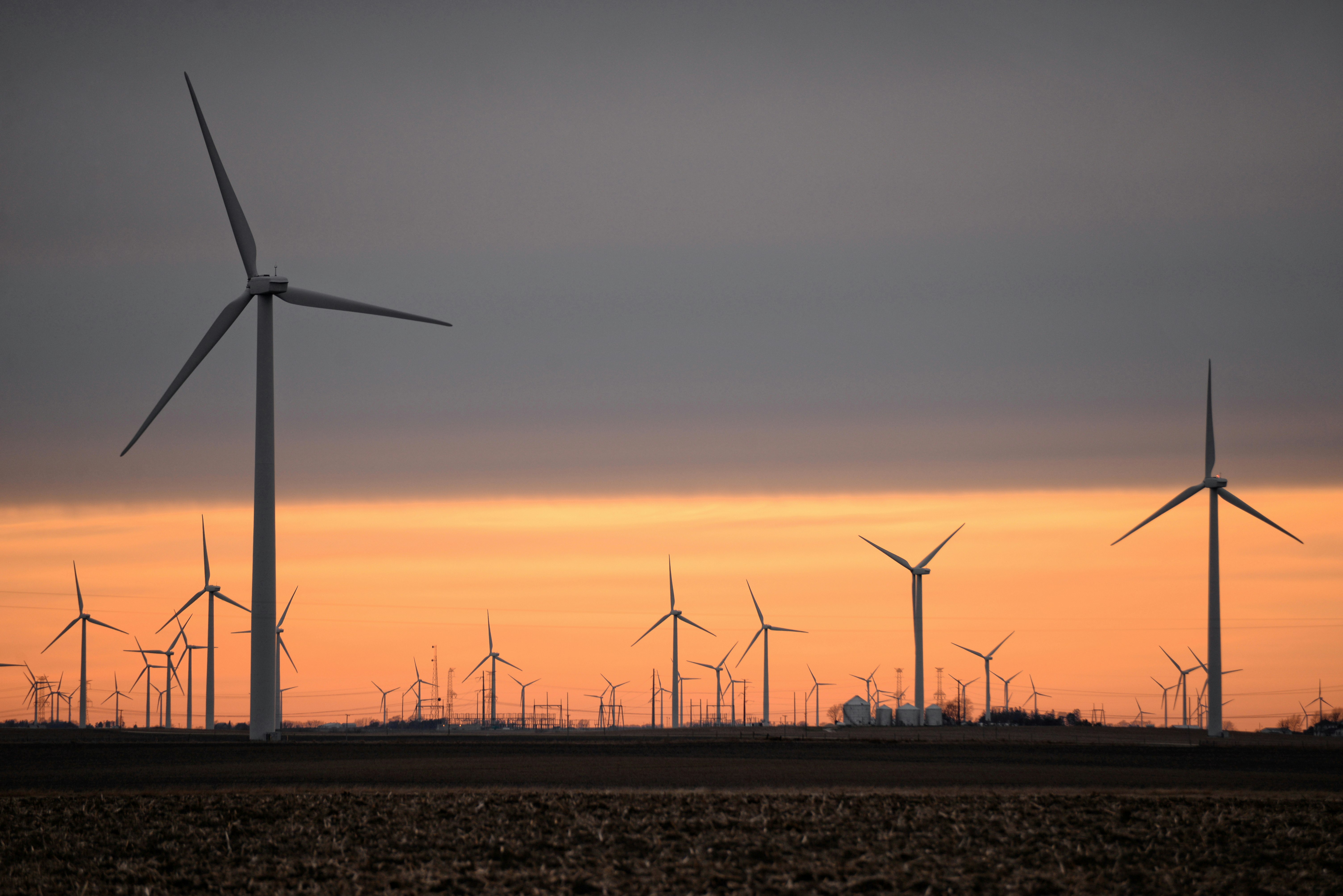 wind turbines on brown field during sunset